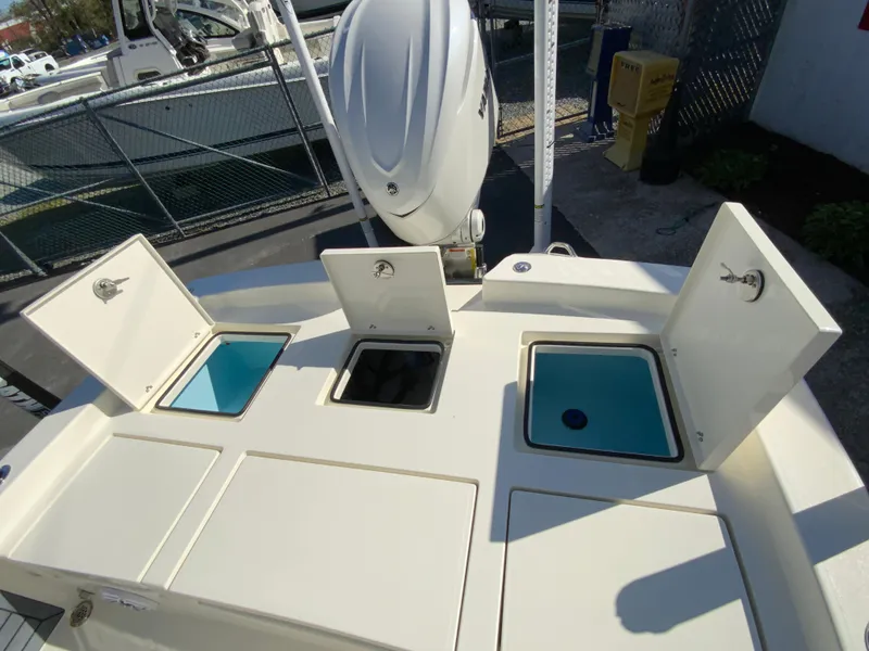 Slide: The Image of 2025 Pathfinder 2600 TRS boat with open storage compartments and outboard motor. - 17