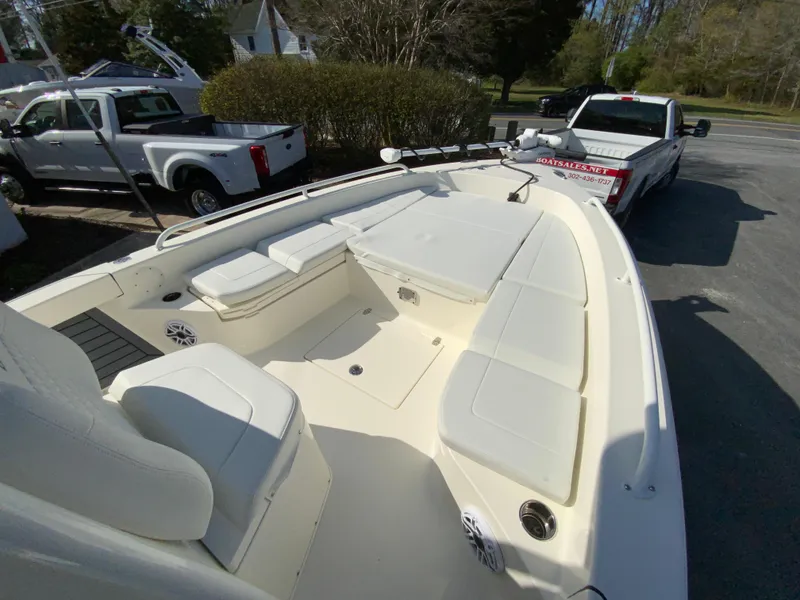 Slide: The Image of 2025 Pathfinder 2600 TRS boat interior with seating, parked near trucks. - 26