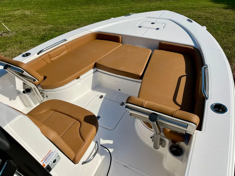 Slide: The Image of 2025 Robalo 226 Cayman boat interior with tan seating and white deck. - 11