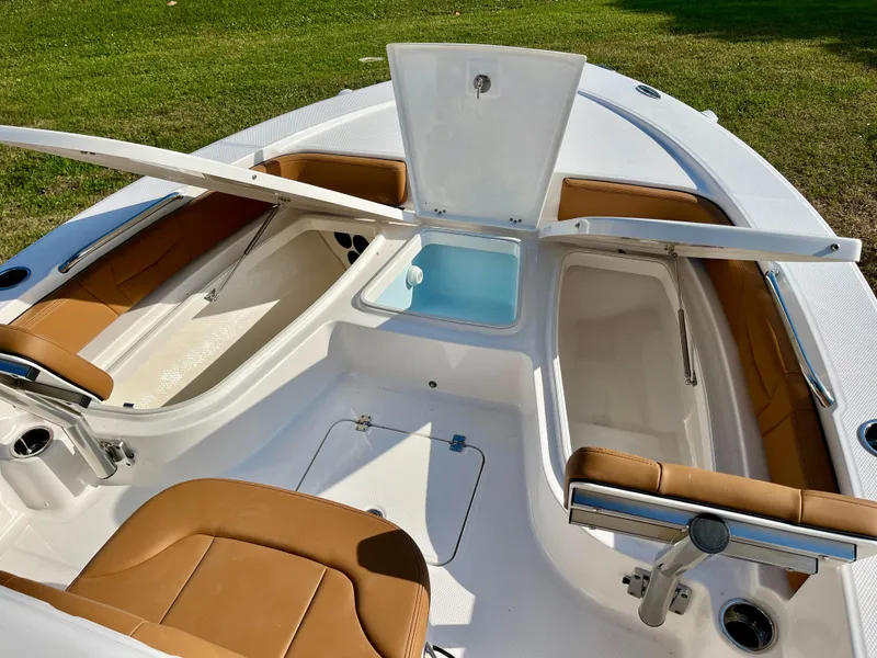 Slide: The Image of 2025 Robalo 226 Cayman boat interior with open storage compartments and seating. - 13