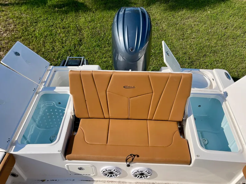 Slide: The Image of 2025 Robalo 226 Cayman boat with tan seating, livewells, and outboard motor. - 15