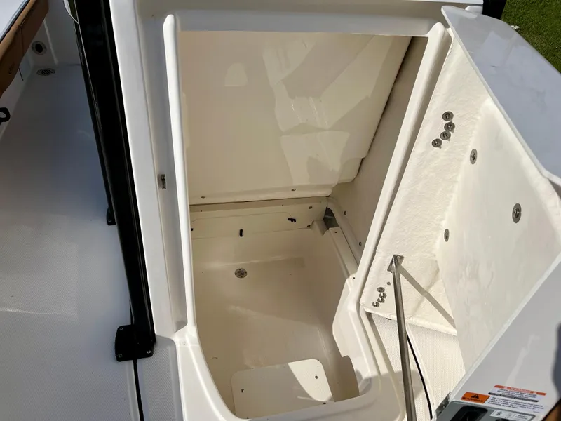 Slide: The Image of 2025 Robalo 226 Cayman storage compartment, open and empty, showcasing interior space. - 17