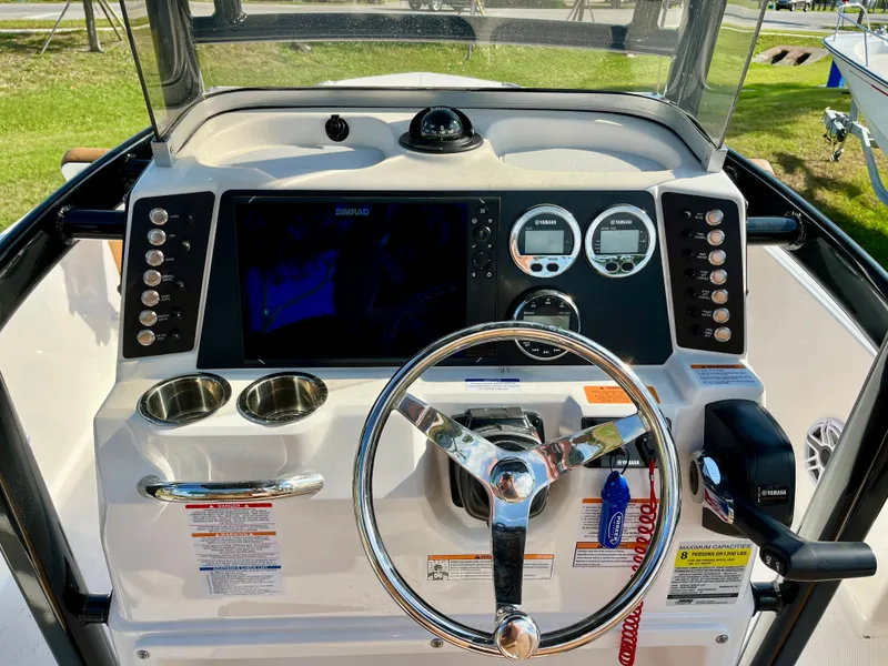 Slide: The Image of 2025 Robalo 226 Cayman boat dashboard with steering wheel and control panel. - 9