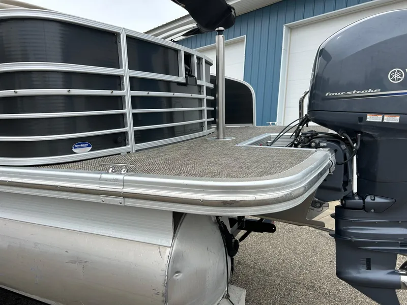 Slide: The Image of 2014 Bennington 2550 RCL pontoon boat with Yamaha outboard motor, docked near blue building. - 13