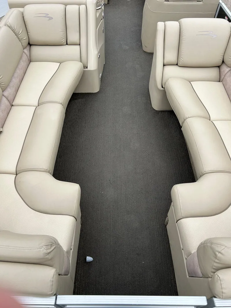 Slide: The Image of 2014 Bennington 2550 RCL boat interior with beige seating and dark carpet flooring. - 16