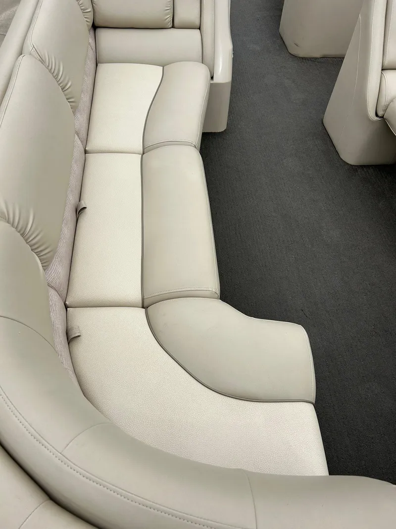 Slide: The Image of 2014 Bennington 2550 RCL boat interior with beige seating and dark carpet flooring. - 17