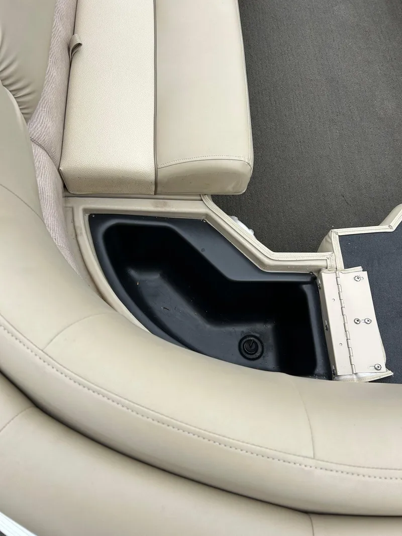 Slide: The Image of 2014 Bennington 2550 RCL boat interior with beige seating and storage compartment. - 18