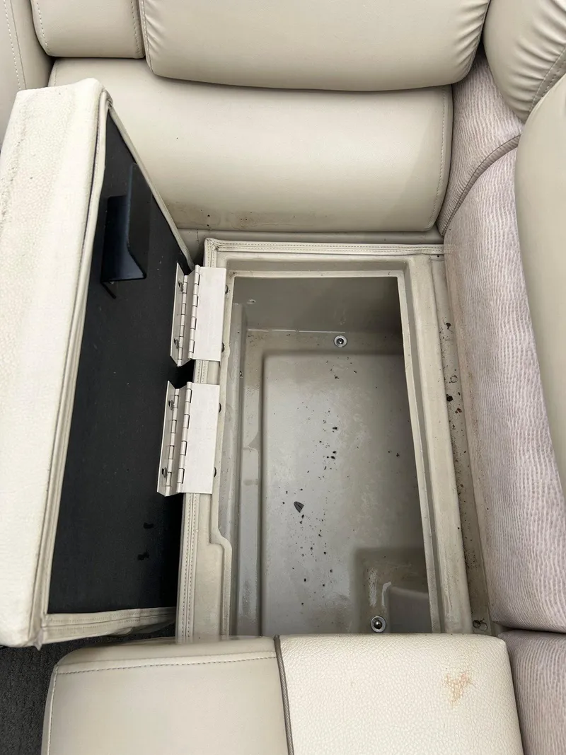 Slide: The Image of Open storage compartment in 2014 Bennington 2550 RCL boat with beige seating. - 25