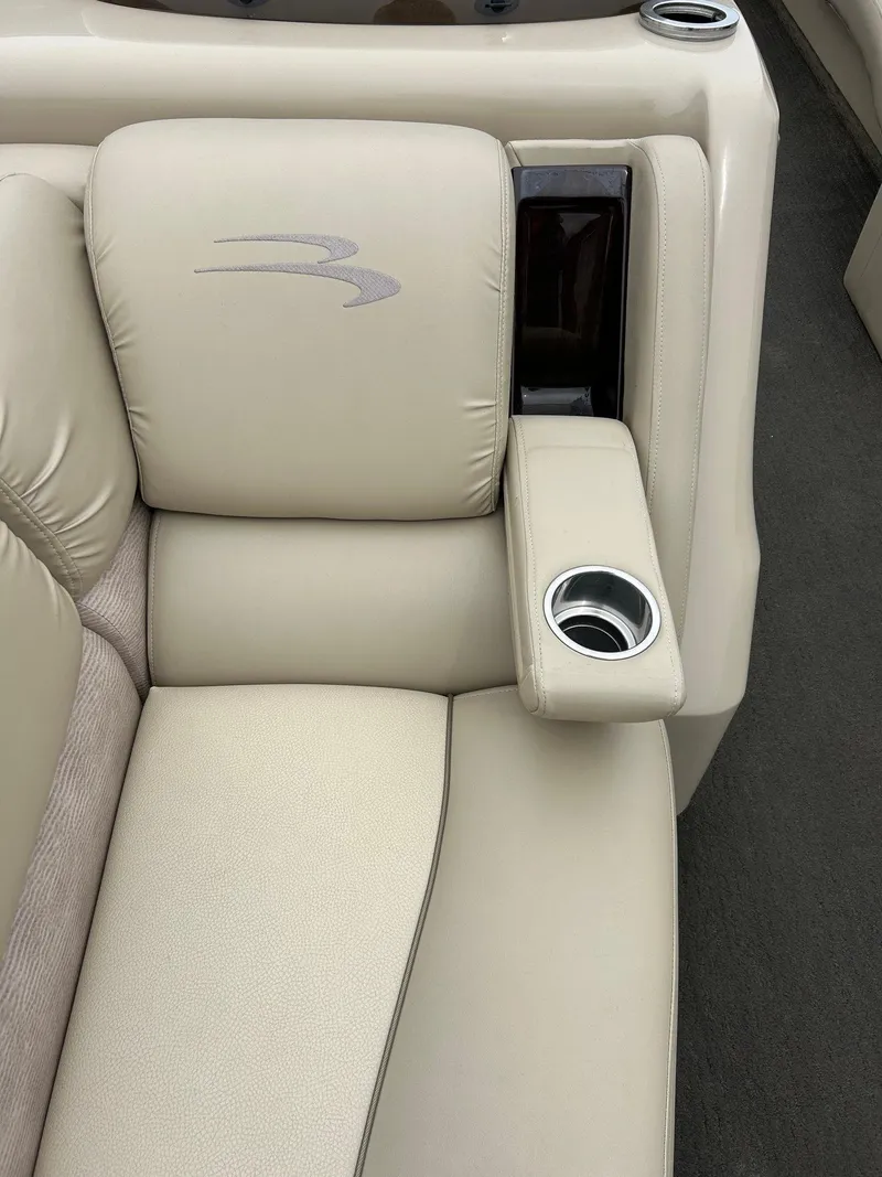 Slide: The Image of 2014 Bennington 2550 RCL boat seat with beige upholstery and built-in cup holder. - 27