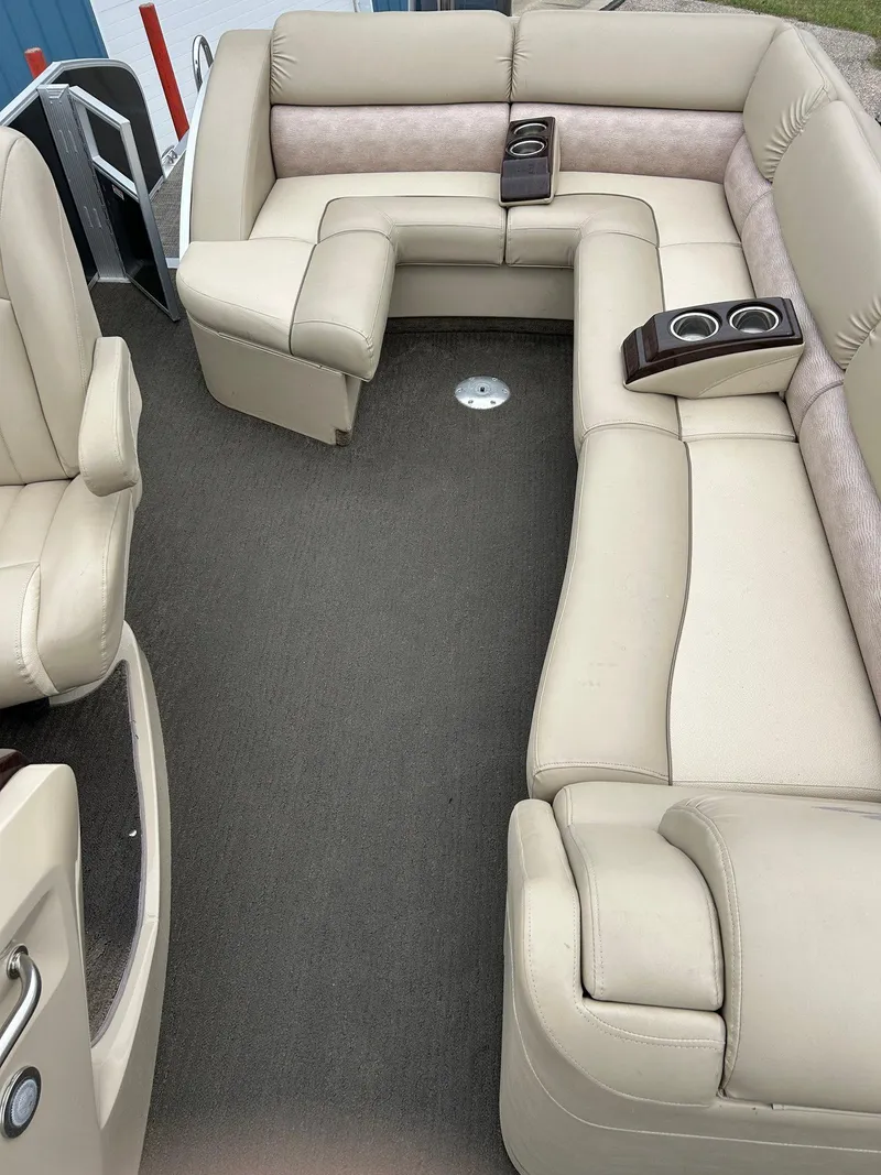 Slide: The Image of 2014 Bennington 2550 RCL boat interior with beige seating and cup holders. - 29