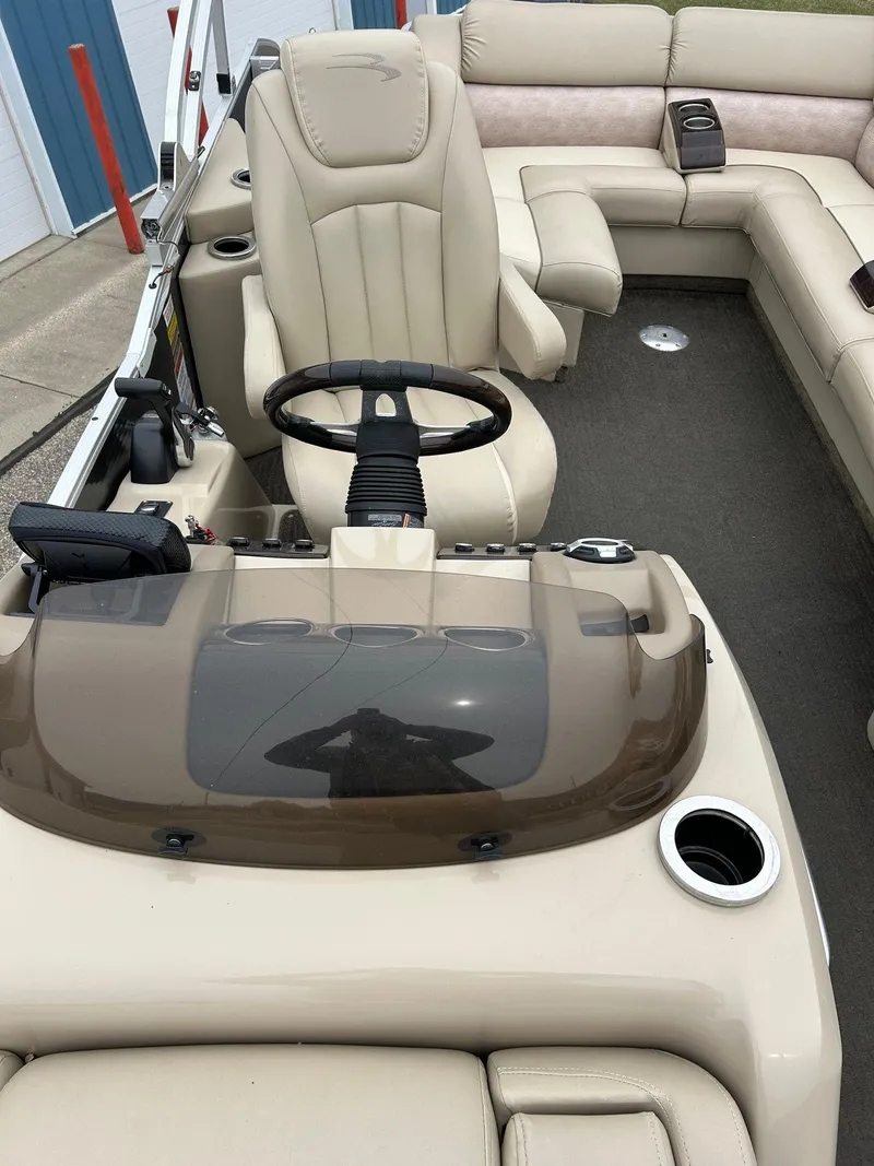 Slide: The Image of 2014 Bennington 2550 RCL boat interior with beige seating and steering console. - 30