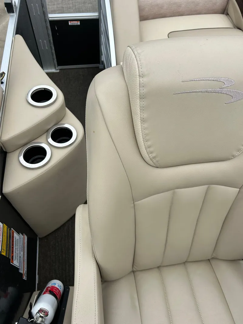 Slide: The Image of 2014 Bennington 2550 RCL boat interior with beige seating and cup holders. - 38