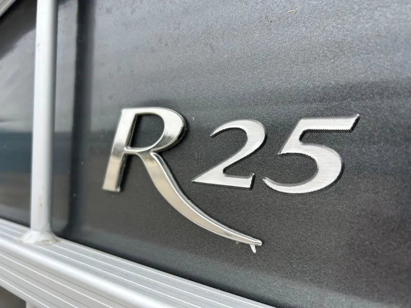 Slide: The Image of 2014 Bennington 2550 RCL boat emblem, featuring "R25" in metallic lettering. - 5