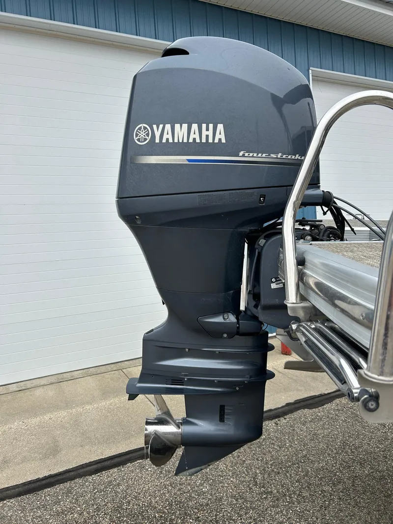 Slide: The Image of Yamaha outboard motor on 2014 Bennington 2550 RCL boat, parked near a garage. - 6