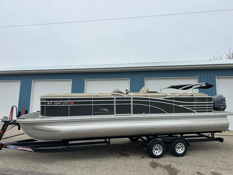Slide: The Image of 2014 Bennington 2550 RCL pontoon boat on trailer, parked outside blue garage. - 9