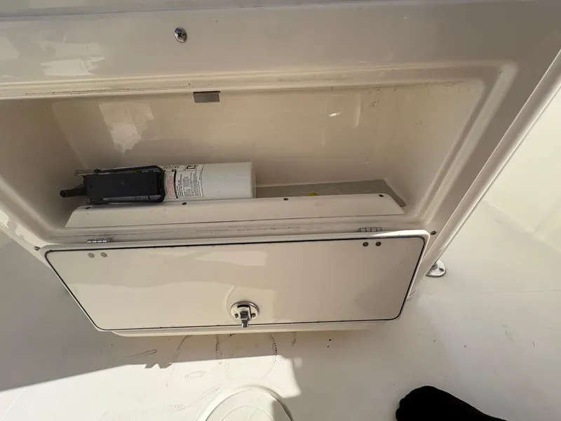 Slide: The Image of 2023 Cobia 237 CC storage compartment with safety equipment inside. - 9