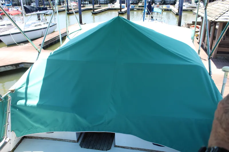 Slide: The Image of 1978 Grand Banks 32 boat with green cover docked at marina. - 12