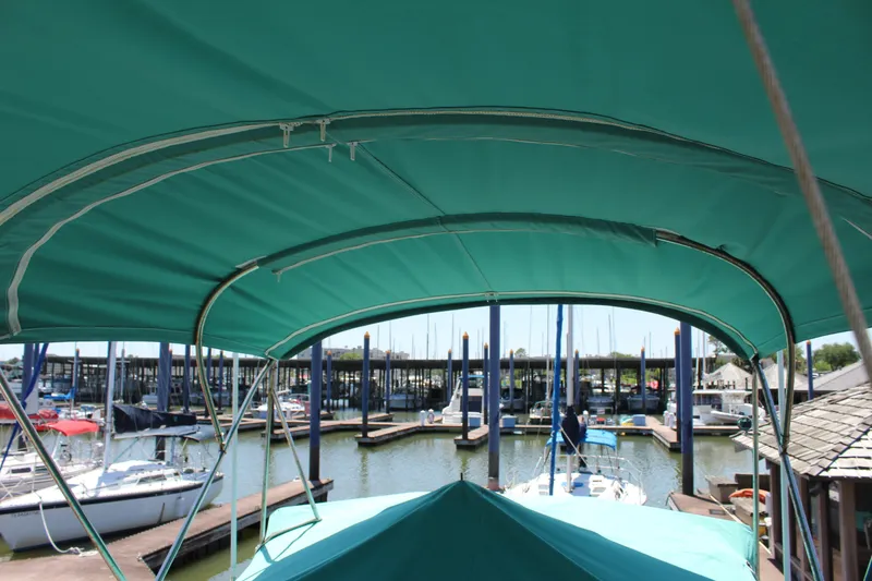 Slide: The Image of 1978 Grand Banks 32 boat with green canopy docked at marina. - 13