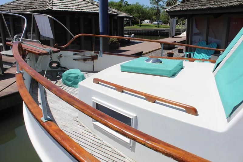 Slide: The Image of 1978 Grand Banks 32 boat deck with wooden railings and teal cushions at a dock. - 15