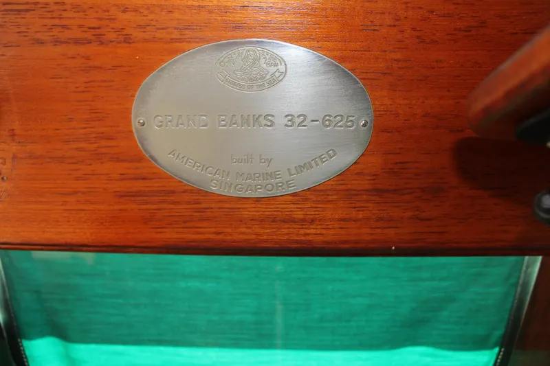 Slide: The Image of 1978 Grand Banks 32 nameplate, built by American Marine Limited, Singapore, on wooden surface. - 26
