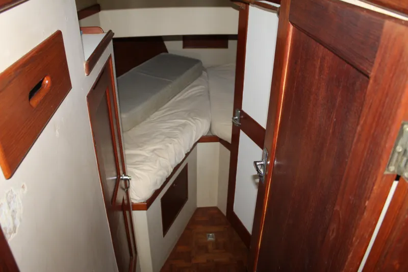 Slide: The Image of 1978 Grand Banks 32 cabin interior with wooden finish and cozy bed. - 29