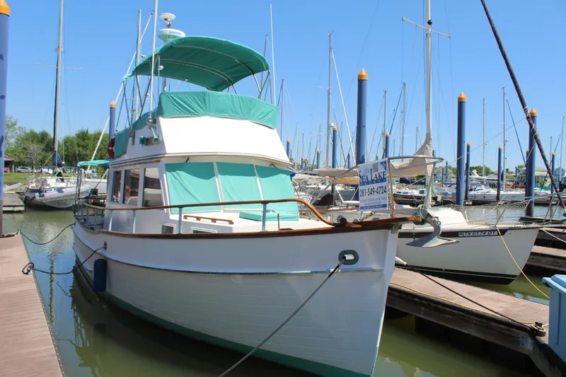 Slide: The Image of 1978 Grand Banks 32 boat docked at a marina on a sunny day. - 3