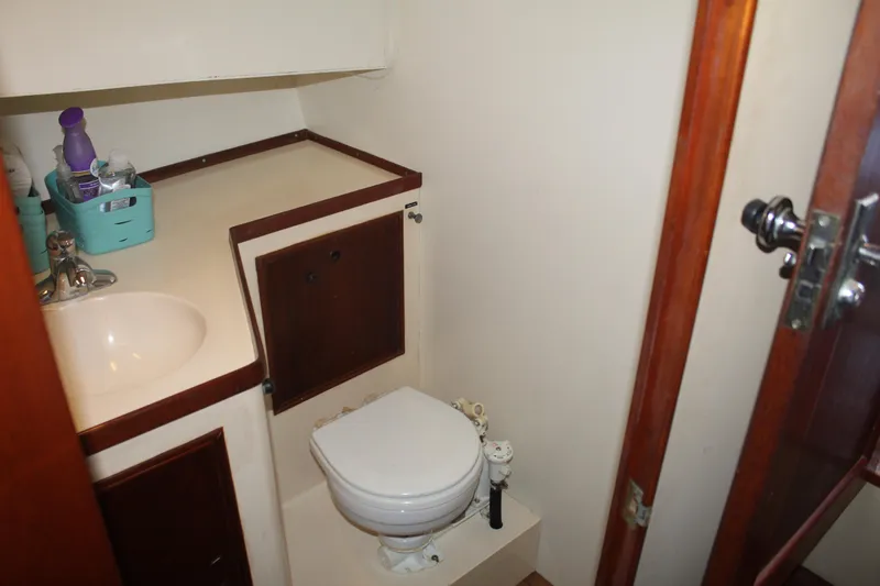 Slide: The Image of 1978 Grand Banks 32 boat bathroom with sink, toilet, and storage cabinet. - 31