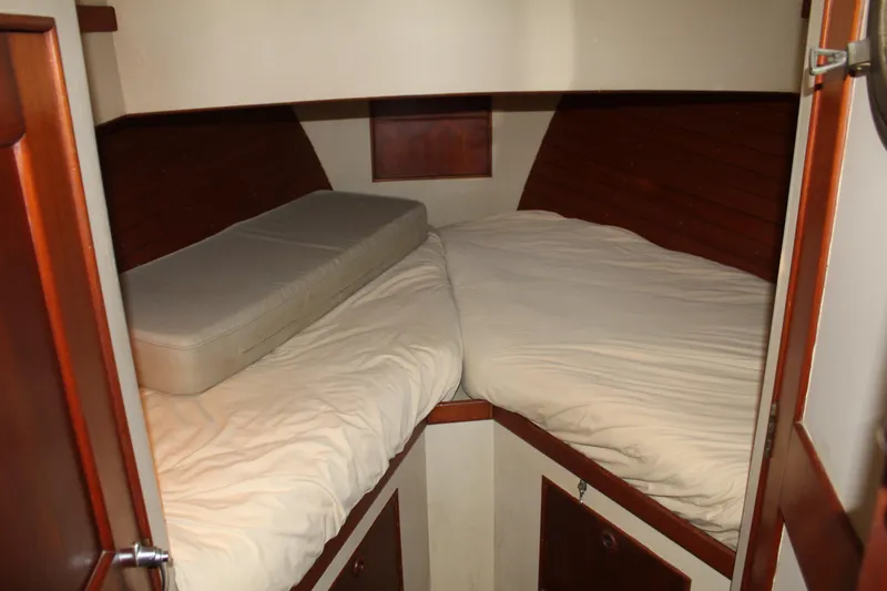 Slide: The Image of 1978 Grand Banks 32 cabin interior with twin beds and wooden paneling. - 32