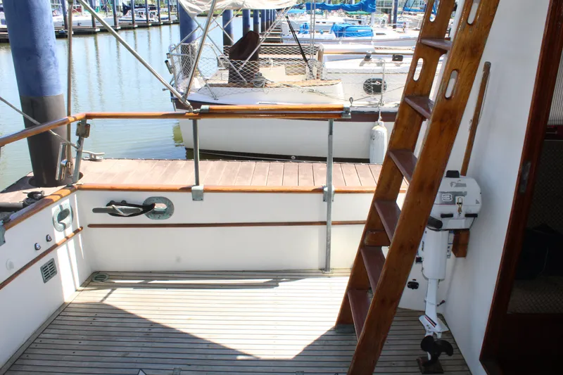 Slide: The Image of 1978 Grand Banks 32 boat deck with wooden ladder and marina view. - 6