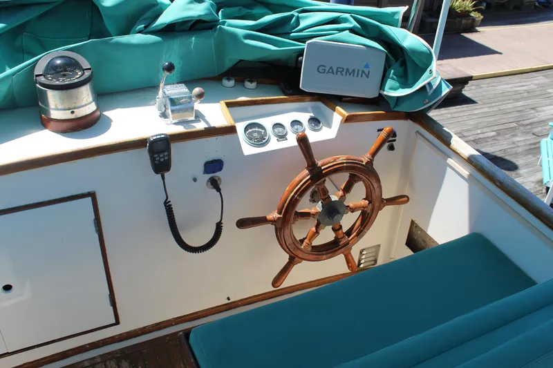 Slide: The Image of 1978 Grand Banks 32 boat helm with wooden wheel, Garmin device, and nautical instruments. - 9