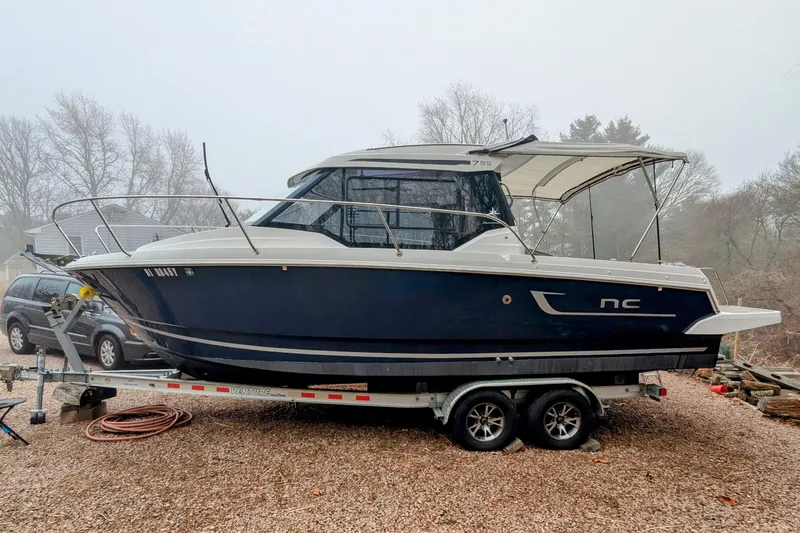 Slide: The Image of 2019 Jeanneau NC 795 boat on trailer, parked outdoors on gravel. - 1