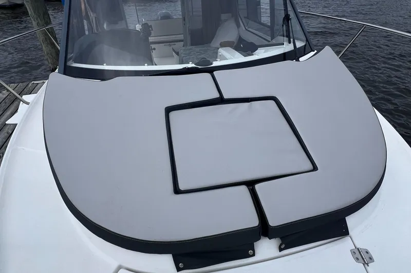 Slide: The Image of 2019 Jeanneau NC 795 boat with cushioned deck, docked by the water. - 13