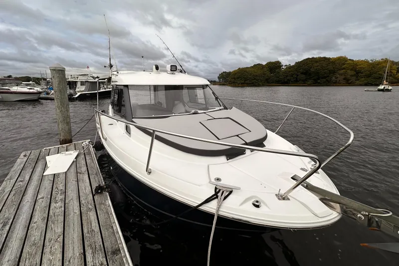 Slide: The Image of 2019 Jeanneau NC 795 boat docked on a calm river under cloudy skies. - 6