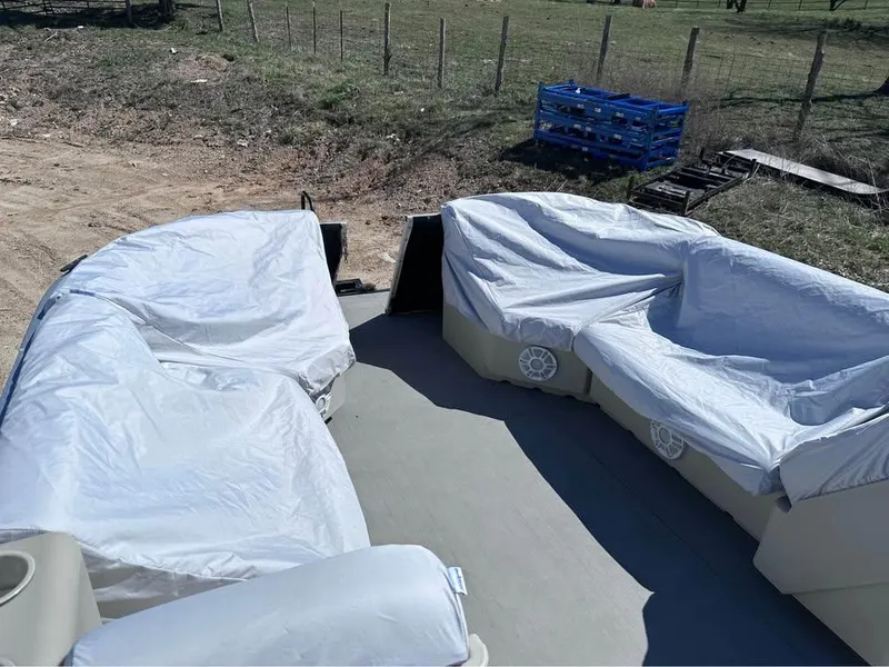 Slide: The Image of Pontoon boat interior with covered seats, Crest Ultra ET 2000 model, in a rural setting. - 12