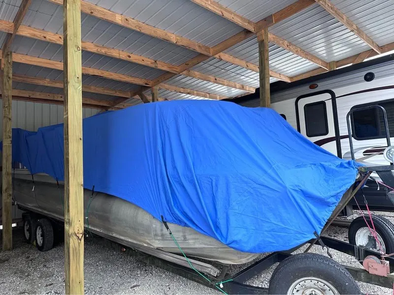 Slide: The Image of Covered 2000 Crest Ultra ET boat under shelter with blue tarp. - 5