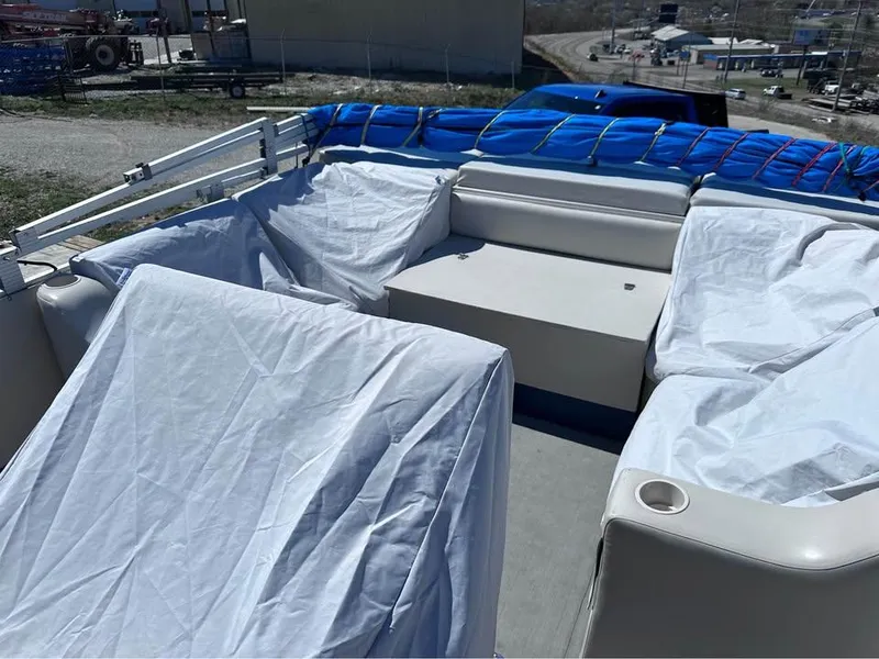 Slide: The Image of 2000 Crest Ultra ET boat interior with covered seating and blue tarp. - 9