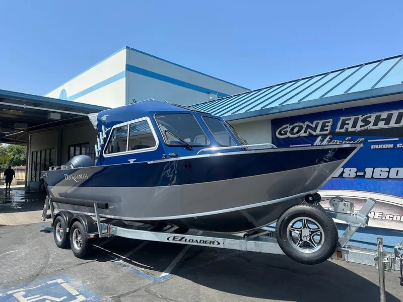 Slide: The Image of 2025 Duckworth 21 Discovery boat on trailer outside a fishing store. - 1