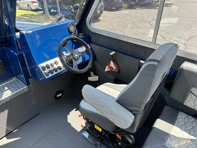 Slide: The Image of Interior of 2025 Duckworth 21 Discovery boat, featuring steering wheel and control panel. - 21