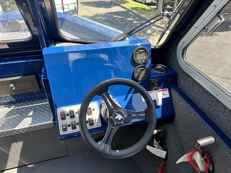 Slide: The Image of Interior of 2025 Duckworth 21 Discovery boat with steering wheel and control panel. - 22