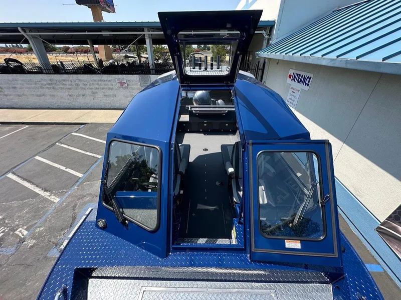 Slide: The Image of 2025 Duckworth 21 Discovery boat with open cabin doors, parked outdoors. - 31