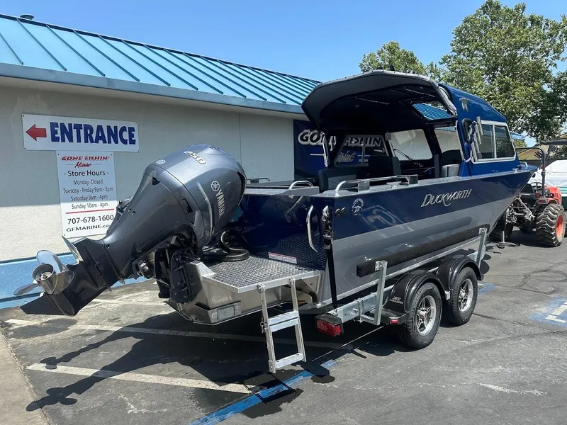 Slide: The Image of 2025 Duckworth 21 Discovery boat on trailer, parked outside a building with blue roof. - 5