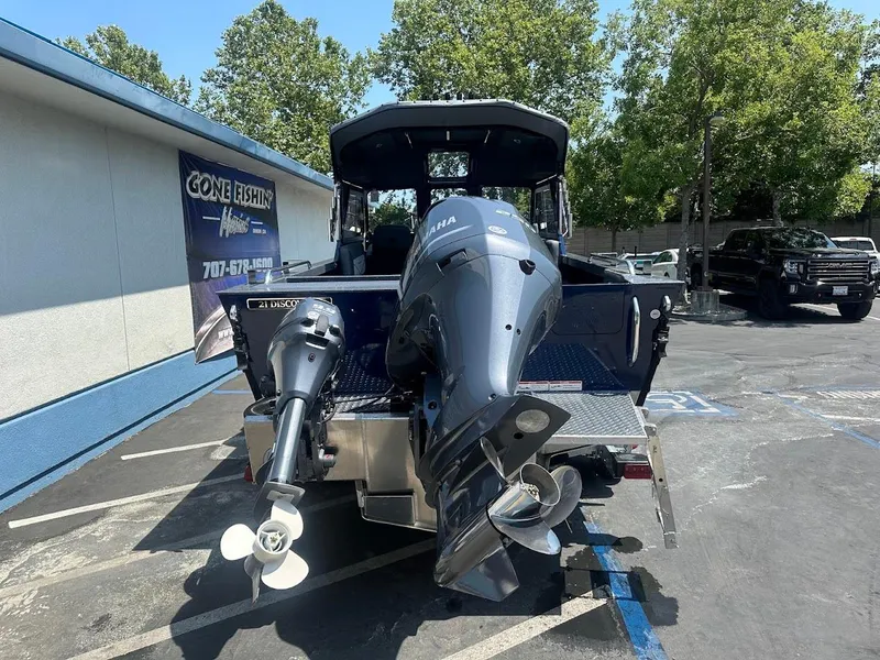 Slide: The Image of 2025 Duckworth 21 Discovery boat with dual outboard motors in a parking lot. - 6