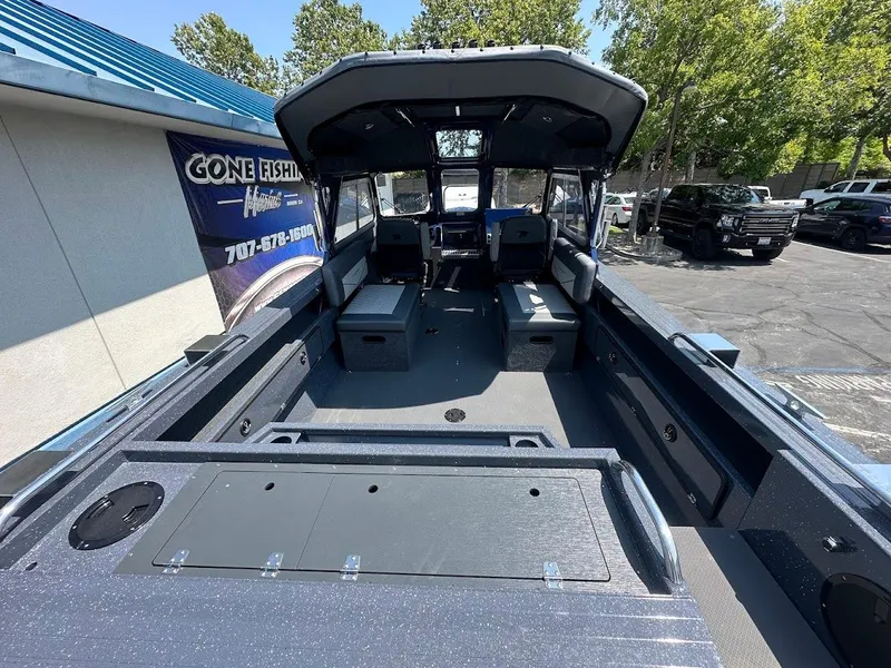 Slide: The Image of 2025 Duckworth 21 Discovery boat interior with seating and storage, parked outdoors. - 8