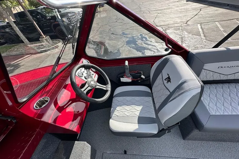 Slide: The Image of Interior of 2025 Duckworth 20 Advantage SE boat with red dashboard and gray seating. - 20