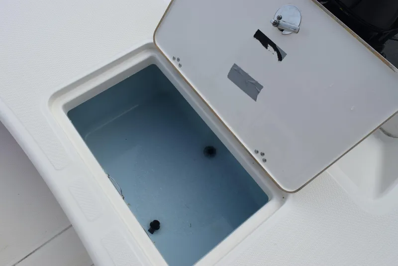 Slide: The Image of 2022 Mako Pro Skiff 17 CC storage compartment with open lid, showcasing interior space. - 11