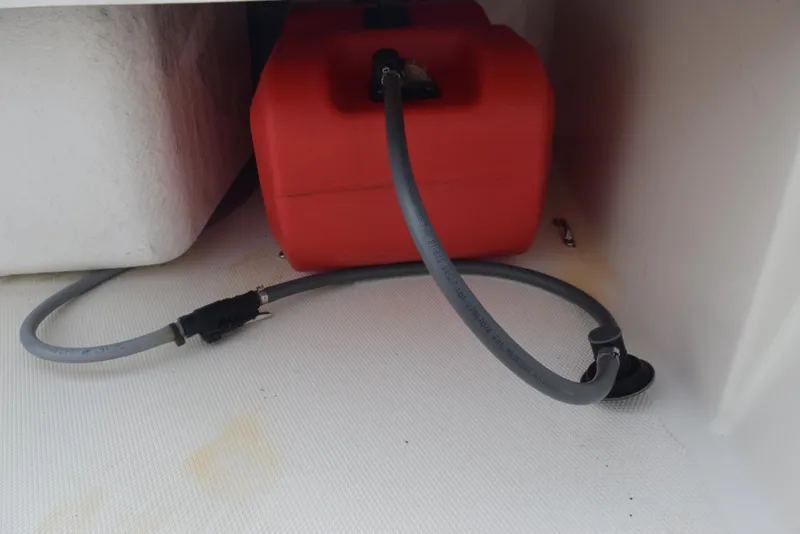 Slide: The Image of Fuel tank and hose in 2022 Mako Pro Skiff 17 CC boat storage compartment. - 13
