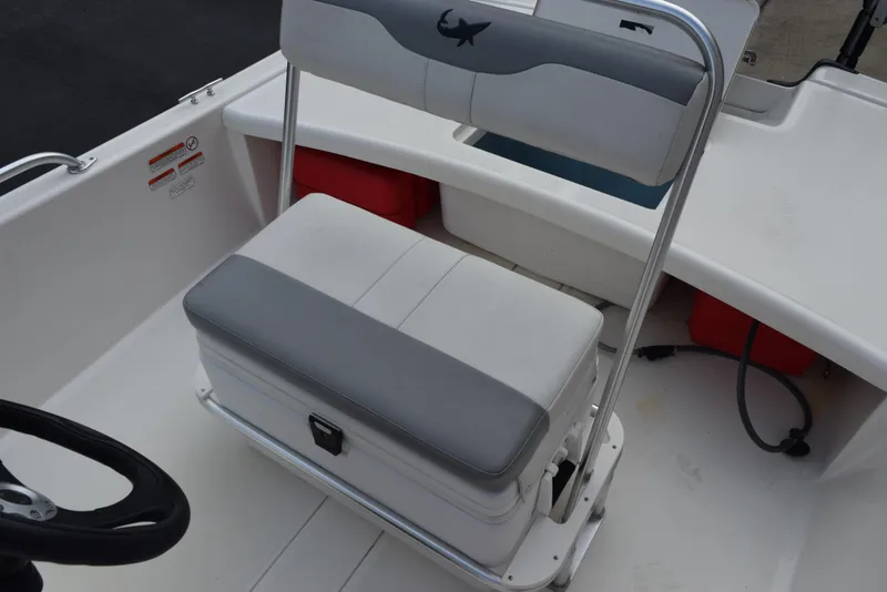 Slide: The Image of 2022 Mako Pro Skiff 17 CC boat seat with storage and steering wheel. - 14