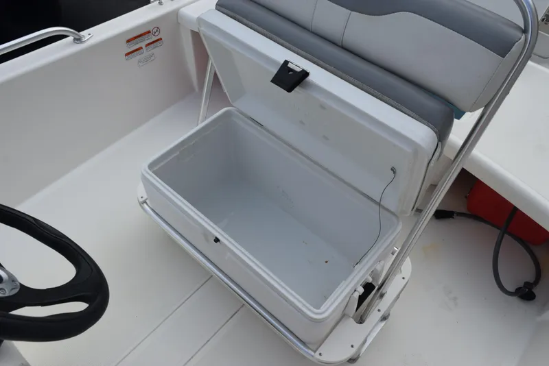 Slide: The Image of 2022 Mako Pro Skiff 17 CC boat seat with open storage compartment. - 15