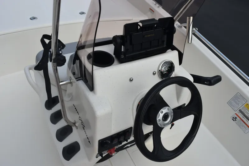 Slide: The Image of 2022 Mako Pro Skiff 17 CC boat console with steering wheel and controls. - 16