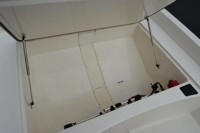 Slide: The Image of 2022 Mako Pro Skiff 17 CC storage compartment with open lid and hydraulic supports. - 19